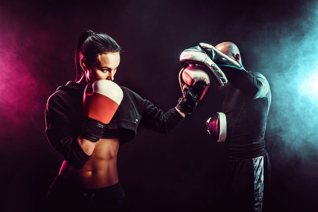 woman-exercising-with-trainer-at-boxing-and-self-defense-lesson.jpg